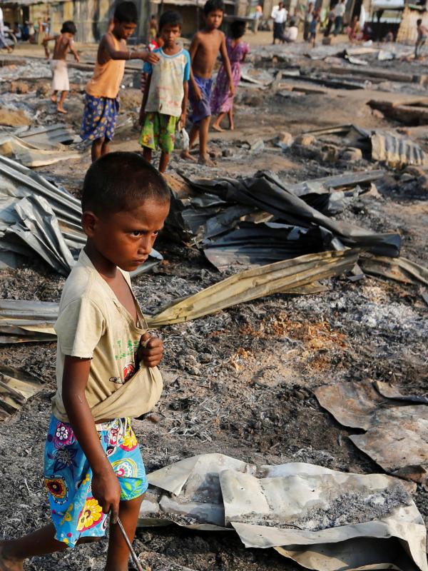 Seorang anak berjalan di antara puing setelah kebakaran kamp pengungsi Muslim Rohingya di Rakhine, Myanmar, Selasa (3/5). Kamp itu tempat penampungan kelompok Rohignya yang tersingkir dari pertikaian dengan kelompok lain pada 2012. (REUTERS/Soe Zeya Tun)