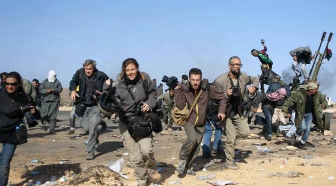 Beberapa wartawan berlari melindungi diri dari serangan bom di Libya. (Foto: Reuters/Paul Conroy)