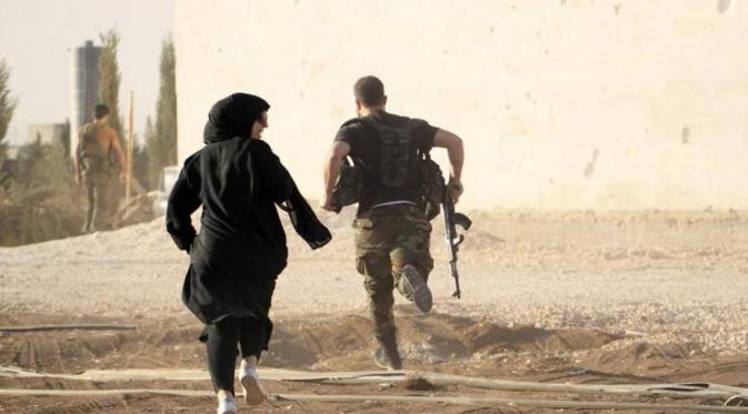 Wartawan wanita berlari menghindari penembak jitu. (Foto: Reuters/Jalal Al-Mammo)