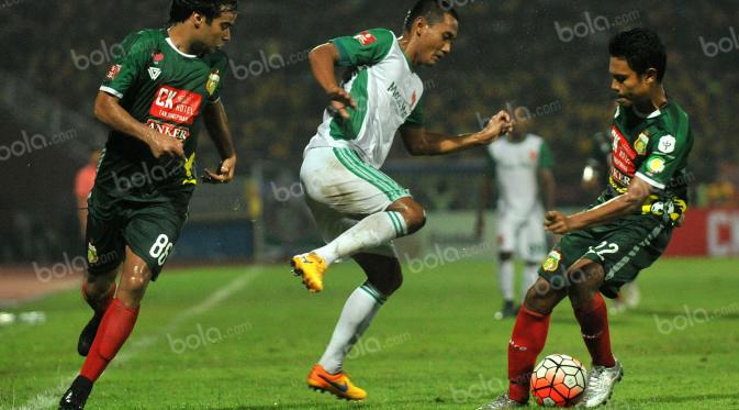 Pemain PS TNI, Legimin Raharjo (tengah), berusaha melewati hadangan pemain Bhayangkara Surabaya United dalam laga Torabika Soccer Championship 2016 presented by IM3 Ooredoo di Stadion Gelora Delta, Sidoarjo, Minggu (8/5/2016). (Bola.com/Fahrizal Arnas)