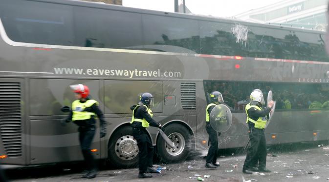 Suporter West Ham United menyerang bus skuat Manchester United di depan Stadion Boleyn Ground, Selasa (10/5). Aksi anarkis itu sampai melubangi jendela bus dan seorang polisi London serta satu warga dikabarkan mengalami luka ringan. (Reuters/Eddie Keogh)