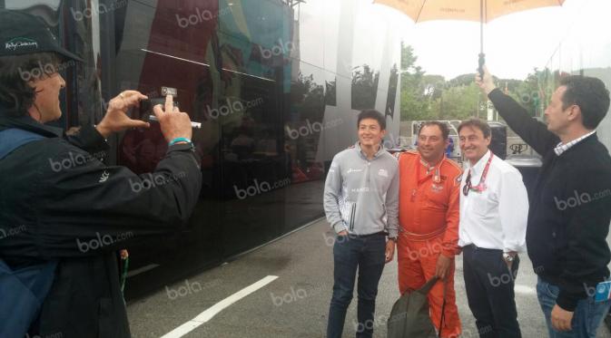 Pebalap Manor Racing asal Indonesia, Rio Haryanto, berfoto bersama seorang panitia lomba dan Adrian Campos (baju putih) seusai latihan bebas kedua F1 GP Spanyol di Sirkuit Catalunya, Spanyol, Jumat (13/5/2016). (Bola.com/Reza Khomaini)