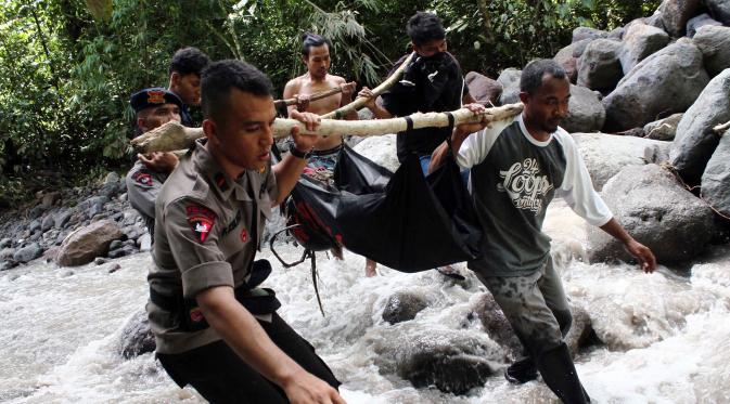 Petugas dan warga saat mengevakuasi jenazah korban banjir bandang di kawasan Air Terjun Dua Warna, Deli Serdang, Sumatera Utara, Senin (16/5). Saat banjir bandang terjadi sekitar 80 orang yang berkemah di tempat tersebut. (ALBERT DAMANIK / AFP)