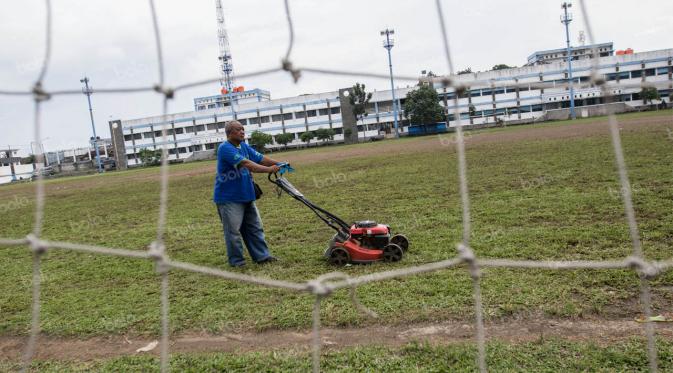 Penjaga stadion, Sudana, memotong rumput di Stadion Sidolig, Bandung, Minggu (1/5/2016). (Bola.com/Vitalis Yogi Trisna)