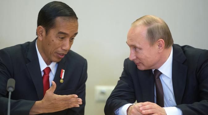 Presiden RI, Jokowi dan Presiden Rusia, Vladimir Putin (kanan) berbincang disela upacara penandatanganan seusai pertemuan di Sochi, Rusia, Rabu (18/5). Kedua pemimpin negara itu melakukan pertemuan bilateral sebelum KTT ASEAN-Rusia (Host Photo Agency/AFP)