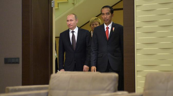 Presiden Rusia, Vladimir Putin (kanan) bersama Presiden RI, Jokowi berjalan ke aula untuk melakukan pertemuan di Sochi, Rusia, Rabu (18/5). Keduanya melakukan pertemuan bilateral sebelum KTT ASEAN-Rusia. (Alexei Druzhinin/Sputnik/Kremlin via Reuters)