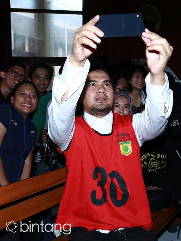 Dengan meminjam Handphone salah satu wartawan yang sedang mewawancari dirinya, ia menyempatkan melakukan selfie dengan wartawan. (Deki Prayoga/Bintang.com)