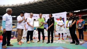 Dirut PPK GBK, Winarto (baju hijau) menerima penghargaan rekor MURI usai gelaran Gelora Run 2016 di Stadion GBK Jakarta, Minggu (22/5/2016). 2.100 pelari ambil bagian dalam ajang lari melintasi tribun Stadion GBK. (Liputan6.com/Helmi Fithriansyah)