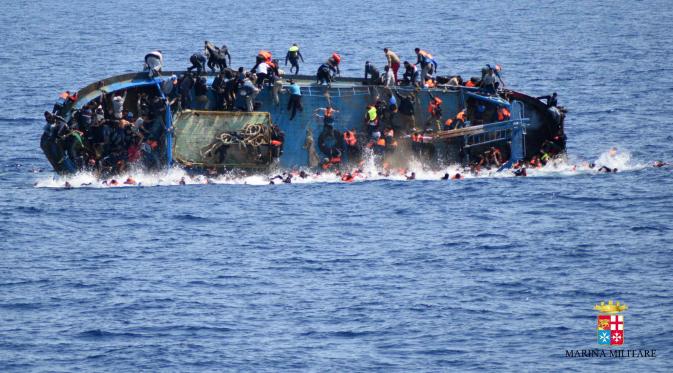 Perahu berpenumpang migran karam di lepas pantai Libya, Rabu (25/5). Angkatan Laut mengatakan 500 orang telah ditarik ke tempat yang aman dan tujuh mayat ditemukan, tetapi operasi penyelamatan terus dilakukan dan angka kematian bisa meningkat. (AFP PHOTO)