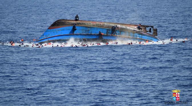 Foto yang dirilis Angkatan Laut (AL) Italia menunjukkan sebuah perahu yang berisi para migran terbalik di lepas pantai Libya, Rabu (25/5). Ratusan migran menceburkan diri ke laut, beberapa lainnya berusaha menyelamatakan diri (STR/AFP MARINA MILITARE/AFP)