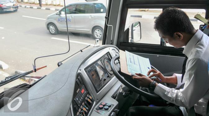 Pramudi bus Transjakarta mengisi data saat tiba di halte busway Pasar Baru, Jakarta, Kamis (26/5/2016). Transjakarta perluasan wilayah cakupan rute hingga ke Kota Tangerang. (Liputan6.com/Yoppy Renato)