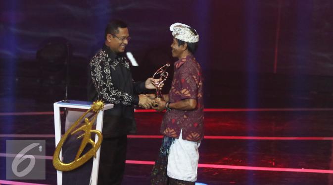 Menteri perindustrian Saleh Husin, memberikan piala penghargaan kepada I Wayan Patut Raih dalam ajang Liputan6 Awards 2016 SCTV Kategori Lingkungan Hidup di Studio 6 Emtek City, Jakarta, Kamis (26/5/2016). (Liputan6.com/Herman Zakharia)