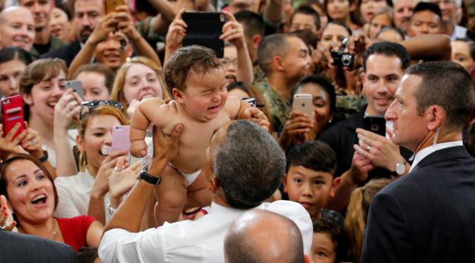 Anak Bayi tanpa busana menangis saat di gendong Presiden AS Barack Obama di Stasiun Udara Korps Marinir Iwakuni, Jepang (27/5). Kedatangan Obama ke Jepang untuk mennghadiri pertemuan G7. (REUTERS/Carlos Barria)