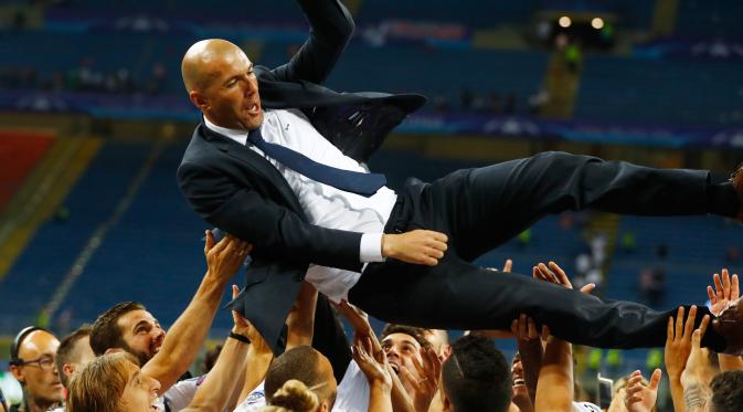 Pemain Real Madrid melempar Zinedine Zidane ke udara usai memastikan gelar Liga Champions ke-11. (Reuters/Kai Pfaffenbach)