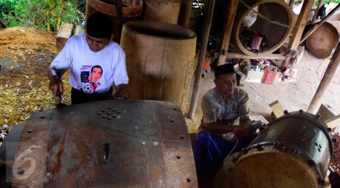 Pekerja  sibuk membuat ukiran di atas kayu bulat besar untuk dijadikan bedug di Desa Bleder, Ngasinan, Grabag, Magelang, Jawa Tengah, Minggu (5/6/2016). (Liputan6.com/Gholib)