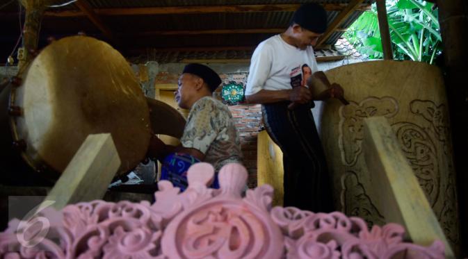 Pekerja  sibuk membuat ukiran di atas kayu bulat besar untuk dijadikan bedug di Desa Bleder, Ngasinan, Grabag, Magelang, Jawa Tengah, Minggu (5/6/2016). (Liputan6.com/Gholib)