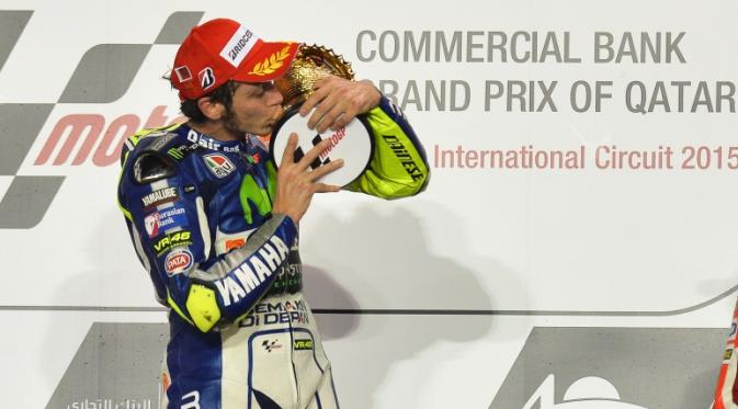 Pebalap Yamaha, Valentino Rossi, mencium trofi seusai memenangi MotoGP Qatar 2015. (EPA/Stringer)