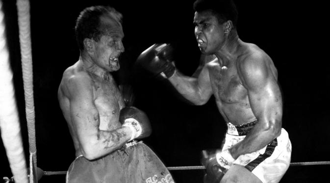 Muhammad Ali saat berhadapan dengan Henry Cooper dalam turnamen tinju untuk gelar World Heavyweight Boxing di Stadion Highbury, London, Inggris, (21/5/1966).  Sebelumnya Ali sudah masuk rumah sakit akibat gangguan pernapasan. (REUTERS/Action Images/MSI)