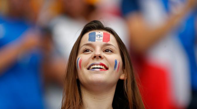 Suporter wanita mewarnai bibir dan wajahnya dengan warna bendera Prancis saat menyaksikan timnya melawan Rumania di ajang kualifikasi grup A Piala Eropa 2016 di stadion Stade de France, Saint-Denis, Paris, Prancis, (10/6). (REUTERS/John Sibley)