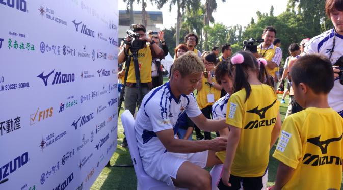 Punggawa AC Milan, Keisuke Honda, saat meladeni sesi tanda tangan peserta Honda Soltilo Soccer School di Lapangan Pertamina, Simprug, Sabtu (11/6/2016). (Liputan6.com/Ahmad Fawwaz Usman)