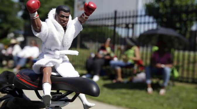 Action figur Muhammad Ali di salah satu sepeda penggemar yang menunggu di jalan. (Mark Humphrey/AP)