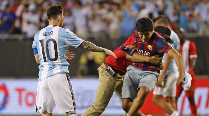 Seorang suporter Argentina menerobos masuk lapangan untuk menghampiri Lionel Messi. (JONATHAN DANIEL / GETTY IMAGES NORTH AMERICA / AFP)