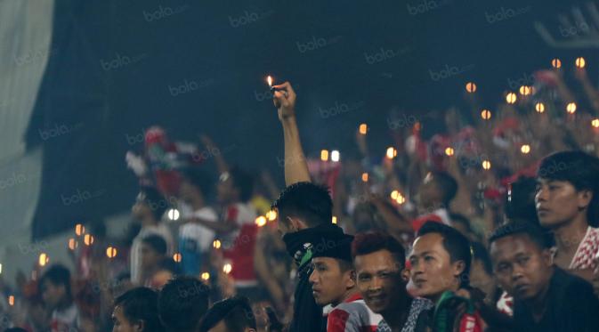 K-Conk Mania menyalakan lilin dan korek api tanda perayaan ulang tahun yang ke-7 saat mendukung timnya Madura United melawan Persiba Balikpapan pada Torabika SC 2016 di Stadion Gelora Bangkalan, Senin(13/6/2016).  (Bola.com/Nicklas Hanoatubun)