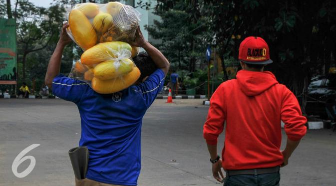 Pembeli usai membeli timun suri di Pasar Kramat Jati, Jakarta, Senin (14/6/2016). (Liputan6.com/Yoppy Renato)