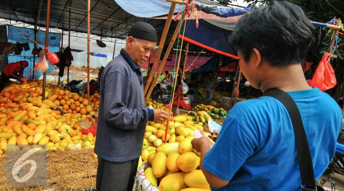 Pembeli saat bertransaksi dengan pedagang timun suri di Pasar Kramat Jati, Jakarta, Senin (14/6/2016). (Liputan6.com/Yoppy Renato)
