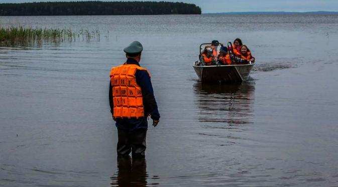 Tim penyelamat membawa anak-anak yang selamat menggunakan perahu (AFP)