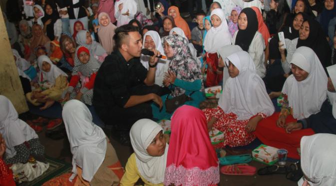 Indra Sinaga, vokalis Lyla Band sedang menghibur anak yatim piatu dalam acara Buka Puasa Bersama PWI Jaya di SMK 2 Yadika, Tanjung Duren, Jakarta Barat. (Liputan6.com)