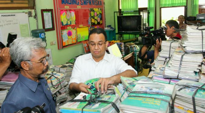 Menteri Anies mengecek buku yang basah akibat banjir di Solo, Jateng. (Reza Kuncoro/Liputan6.com)