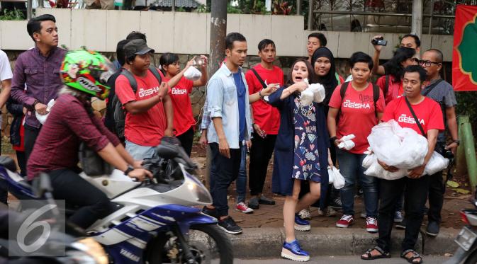 Band Geisha membagi-bagikan takjil di jalan di kawasan Perdatam, Kalibata, Jakarta Selatan. [Foto: Herman Zakharia/Liputan6.com]