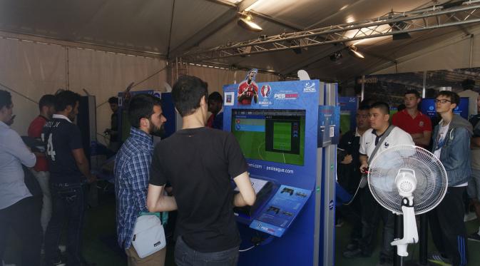 Suporter sedang bertanding game konsol Pro Evolution Soccer (PES) di Fan Zone Piala Eropa 2016 Paris, Prancis, Minggu (26/6/2016). (Bola.com/Ary Wibowo).