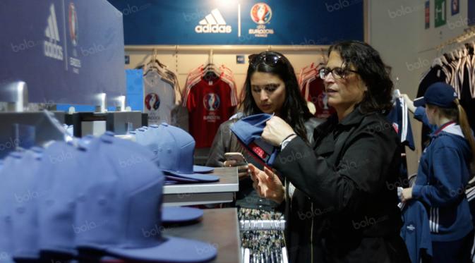 Pengunjung melihat-lihat topi yang terdapat pada souvenir megastrore di fan zone Kota Paris, Prancis, Minggu (25/6/2016). (Bola.com/Vitalis Yogi Trisna).