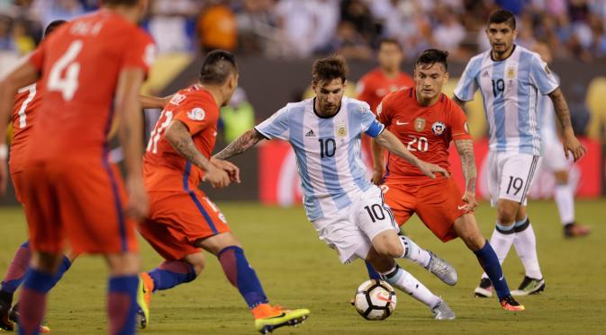 Penyerang Argentina, Lionel Messi berusaha melewati sejumlah pemain Chile pada Final Copa America 2016 di MetLife Stadium, AS, Senin (27/6). Chile menang atas Argentina lewat adu penalti dengan skor 4-2. (Adam Hunger-USA TODAY Sports)