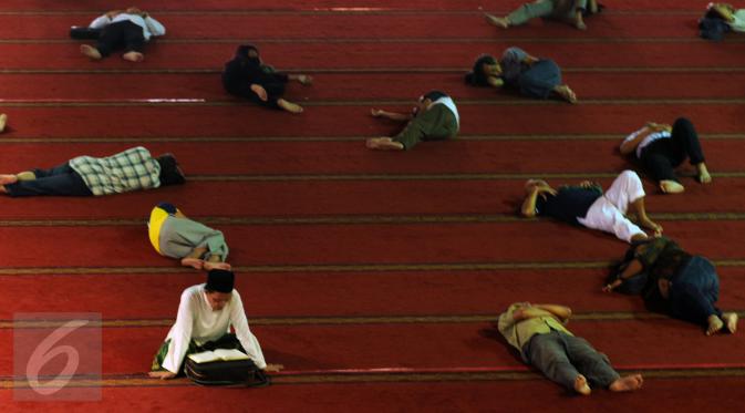 Seorang umat muslim membaca Al Quran di masjid Istiqlal Jakarta, Senin (27/6). 10 hari jelang akhir Ramadan, sejumlah umat muslim dari berbagai daerah melakukan itikaf di masjid Istiqlal Jakarta. (Liputan6.com/Helmi Fithriansyah)