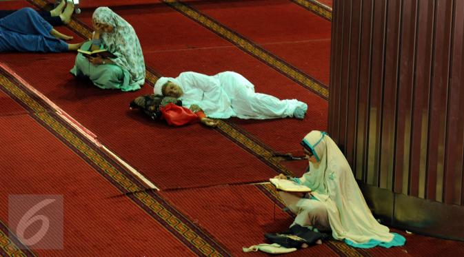 Sejumlah muslimah membaca Al Quran di masjid Istiqlal Jakarta, Senin (27/6). 10 hari jelang akhir Ramadan, sejumlah umat muslim dari berbagai daerah melakukan itikaf di masjid Istiqlal Jakarta. (Liputan6.com/Helmi Fithriansyah)