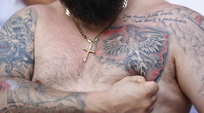 Seorang fan rela menato tubuhnya dengan lambang negara, elang, di dadanya demi mendukung Polandia. (REUTERS/Jason Cairnduff Livepic)