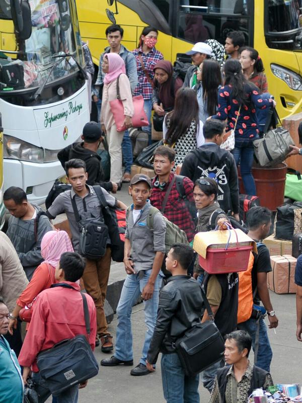 Pemudik bersiap memasuki bus di Terminal Kampung Rambutan, Jakarta, Jumat (1/7). H-5 jelang puncak arus mudik Lebaran 2016, terminal Kampung Rambutan mulai dipadati pemudik. (Liputan6.com/Yoppy Renato)