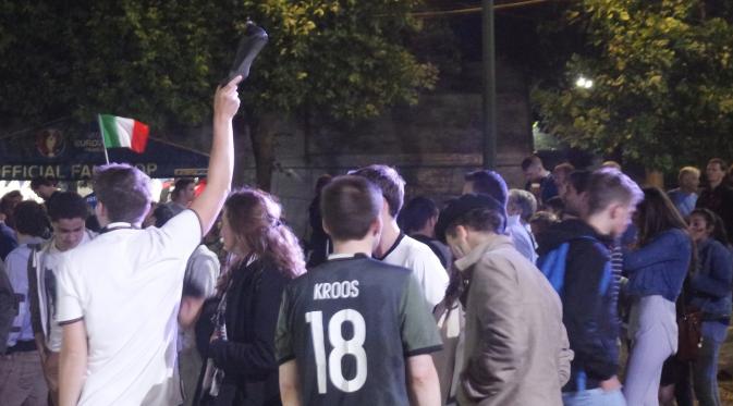 Salah satu suporter sedang mengangkat sepatu yang ditinggal pemiliknya usai terjadi kepanikan di Fan Zone Piala Eropa 2016 Paris, Sabtu (2/7/2016). (Bola.com/Ary Wibowo).