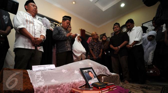 Sejumlah pelayat membaca doa disisi jenazah Ketua KPU, Husni Kamil Manik di kompleks KPU, Jakarta, Jumat (8/7). Husni Kamil Manik wafat pada Kamis (7/7) di usia 40 tahun. (Liputan6.com/Helmi Fithriansyah)