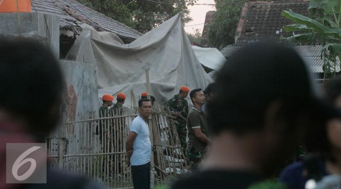 Sejumlah personel TNI AU berjaga di lokasi helikopter jatuh yang sudah di tutup terpal di Dusun Kowang, Sleman (8/7). Heli jatuh setelah melakukan penerbangan dari Solo menuju Yogyakarta. (Liputan6.com/Boy Harjanto)