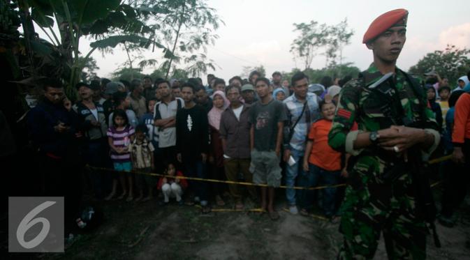 Petugas berjaga di sekitar lokasi helikopter jatuh yang sudah di tutup terpal di Dusun Kowang, Sleman (8/7). Heli jatuh setelah melakukan penerbangan dari Solo menuju Yogyakarta. (Liputan6.com/Boy Harjanto)