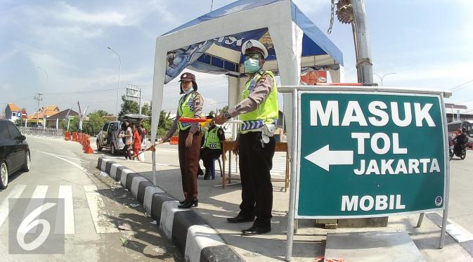 Petugas mengatur lalu lintas usai makan siang di pos pengamanan 06 exit tol Brebes Timur, Jawa Tengah, Sabtu (9/7). (Liputan6.com/Herman Zakharia)