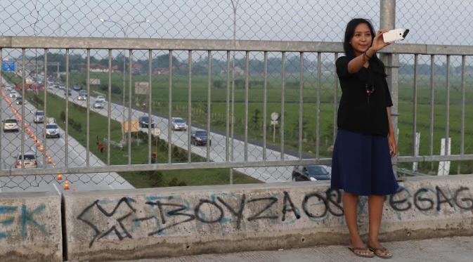 Beberapa warga bahkan selfie untuk mengabadikan kemacetan di Tol Palimanan. (Liputan6.com/Herman Zakaria)