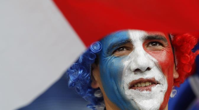Wajah suporter Prancis yang sudah dicat dengan warna sesuai bendera negara mereka. Dukungan siap ia berikan kepada Prancis saat melawan Portugal pada final Piala Eropa 2016 di Stade de France. (Reuters)