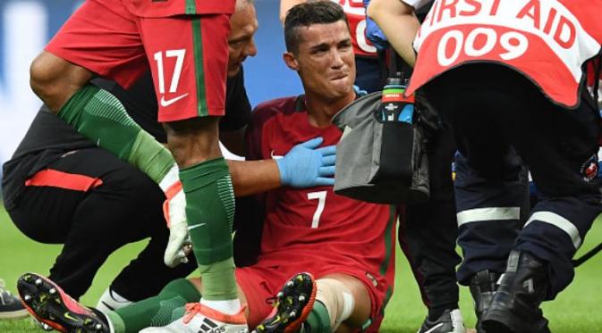 Striker Portugal, Cristiano Ronaldo, menangis karena tidak bisa melanjutkan laga final Piala Eropa 2016 melawan Prancis di Stade de France, Saint-Denis, Minggu (10/7/2016). (AFP/Franck Fife)