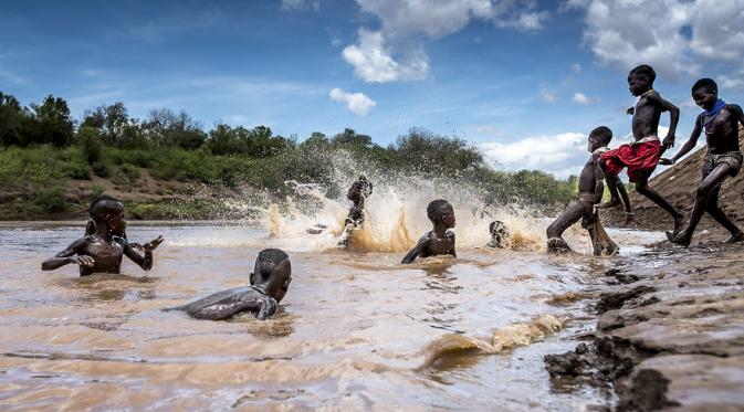 Anak-anak suku Karo bermain di sungai, Lembah Omo, Ethiopia. (Massiomo Rumi/Bored Panda)