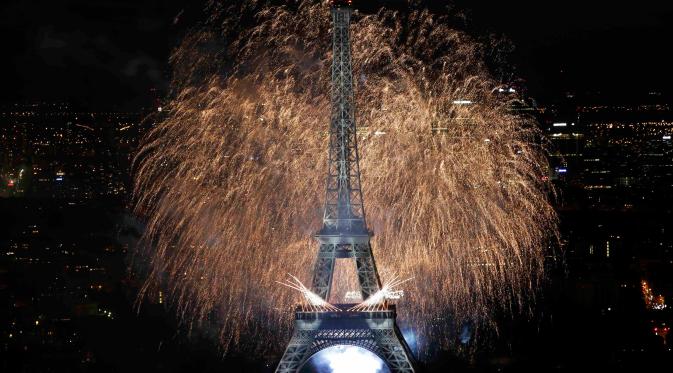 Ledakan kembang api langit menerangi di Menara Eiffel saat perayaan tradisional Hari Bastille di Paris, Prancis, (14/7). Peringatan ini menandai penyerbuan penjara Bastille pada 14 Juli 1789, yang memicu revolusi Prancis. (REUTERS/Pascal Rossignol)
